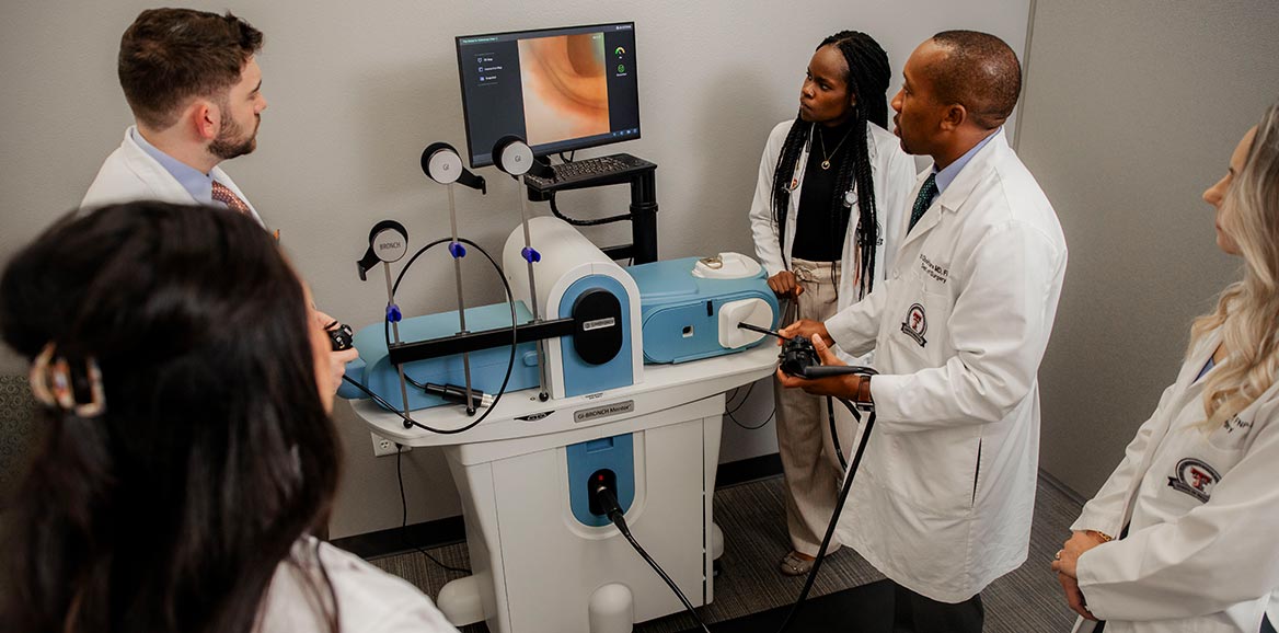 Medical residents and faculty at TTUHSC Amarillo practicing endoscopy skills on a simulation model during surgical training.