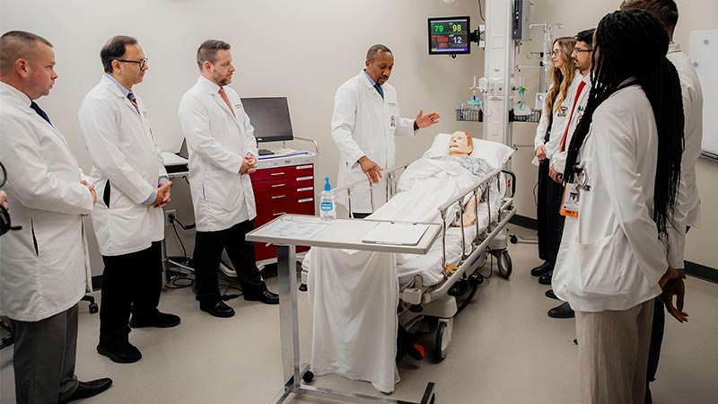 General surgery residents at TTUHSC Amarillo participating in a simulation-based training session with faculty around a patient manikin.