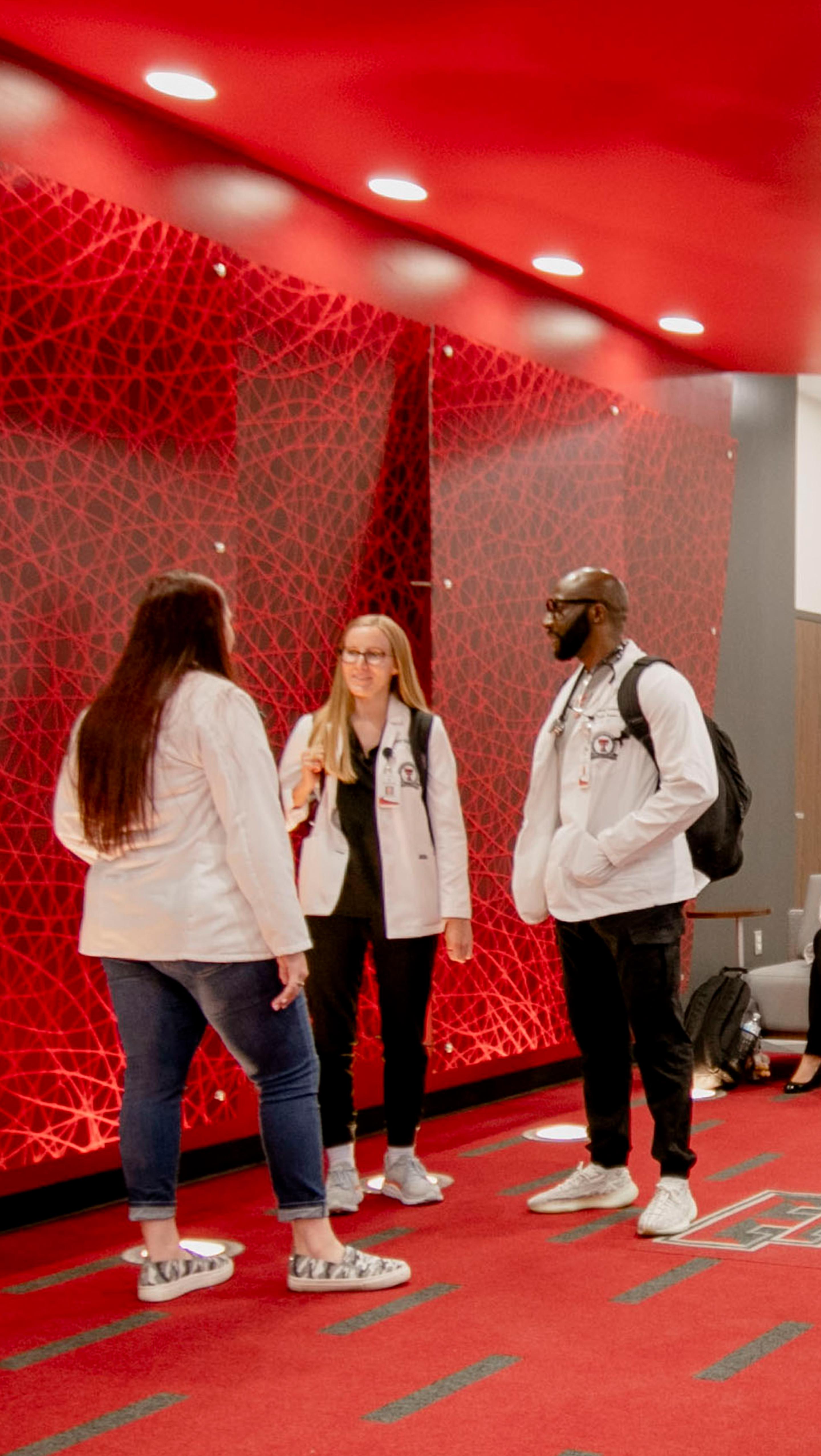 three students talking together while standing