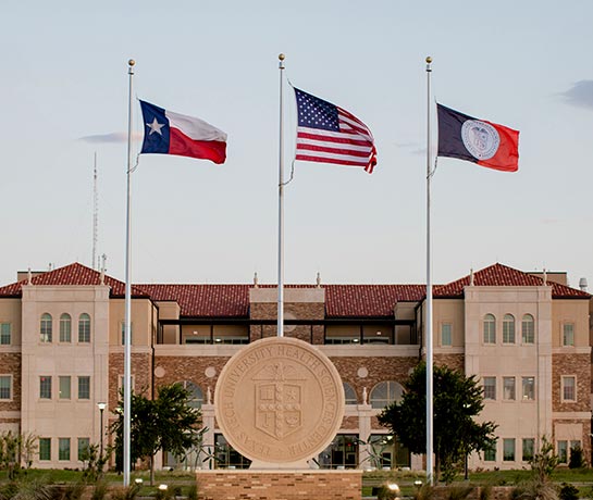 exterior shot of AEC building with flags flying exterior shot of AEC building with flags flying