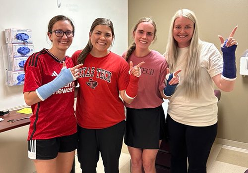 TTUHSC students standing with guns up fingers pointed with temporary casts on
