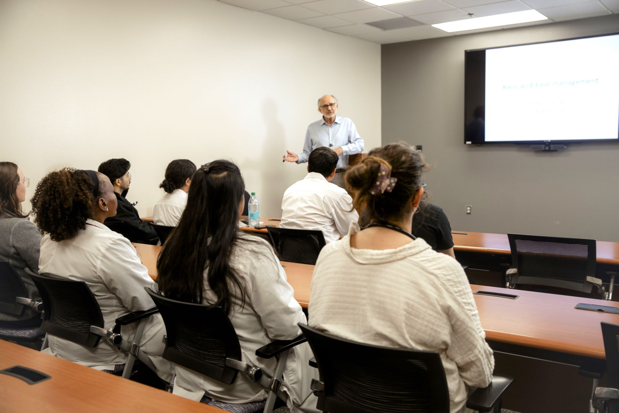 Internal Medicine Residents sitting at a desk in a classroom with an instructor